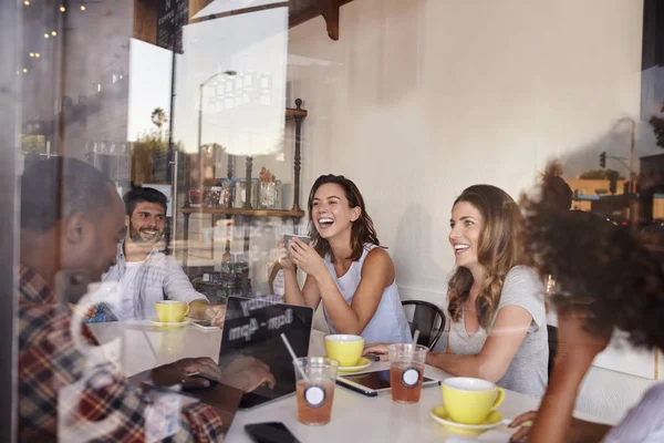 Jonge vrienden opknoping in café — Stockfoto