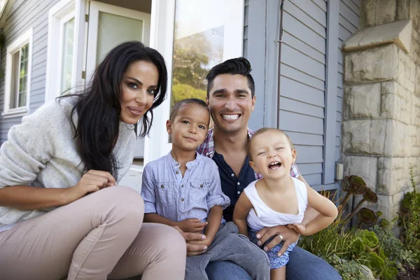 Retrato de la familia sentada en escalones fuera de casa —  Fotos de Stock