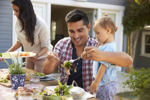 Father holding spoons with salad — Stock Photo, Image