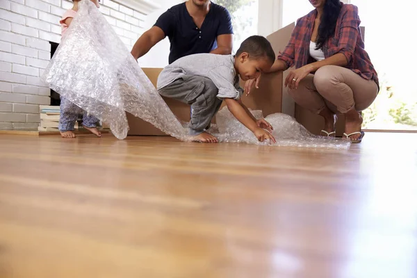 Familie packt Kisten aus und Kinder spielen — Stockfoto
