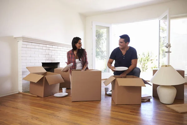Casal segurando placas e desempacotando caixas — Fotografia de Stock
