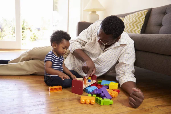 Opa en kleinzoon spelen met speelgoed — Stockfoto