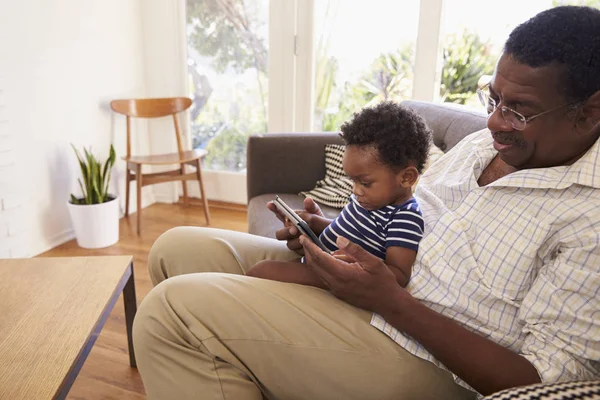 Grand-père et petit-fils à la maison en utilisant une tablette numérique — Photo