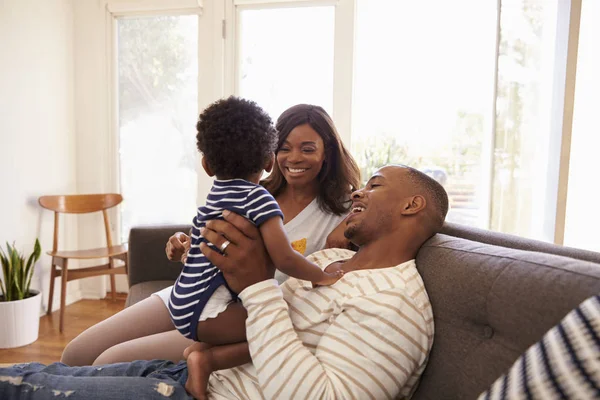 Padres e hijo jugando en el sofá — Foto de Stock