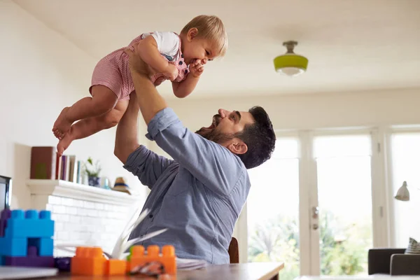 Apa ül asztalnál, és játszik a baba fiú otthon — Stock Fotó