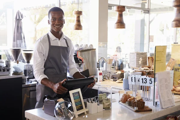 Männliche Mitarbeiter, die an der Kasse stehen und arbeiten — Stockfoto