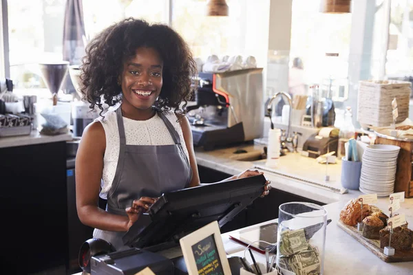 Female employee working and standing at checkout — Stock Photo, Image