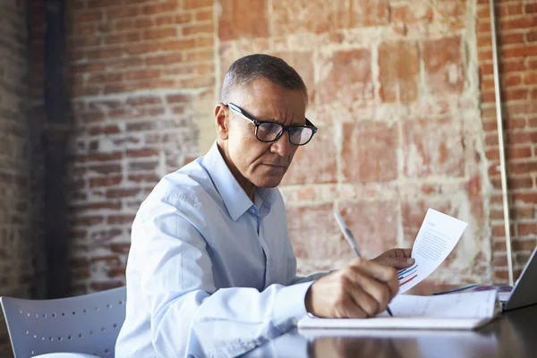 Mature Businessman looking at papers — Stock Photo, Image