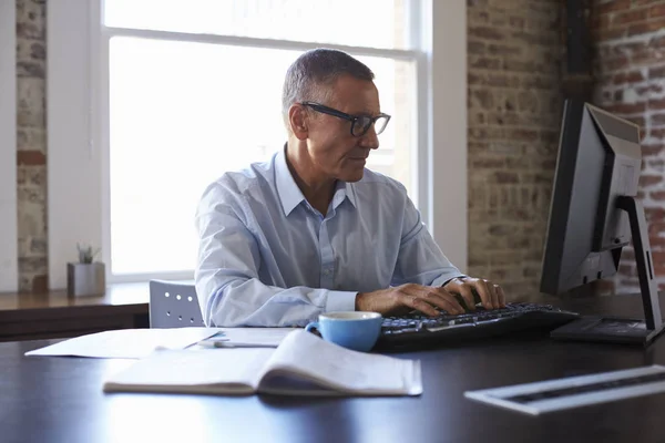 Volwassen zakenman werkt op de computer — Stockfoto