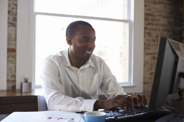 Hombre de negocios sonriente trabajando en la computadora — Foto de Stock