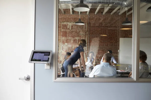 View Through Window Of Businesspeople Meeting Board Room — стоковое фото