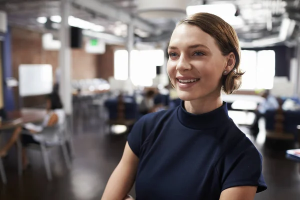 Woman in balck dress smiling at office — Stock Photo, Image