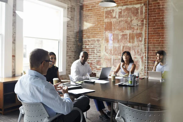 Empresarios sentados a la mesa en la sala de juntas — Foto de Stock