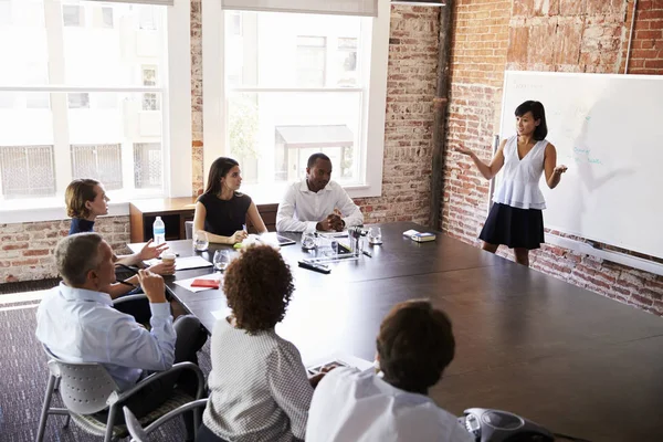 Femme d'affaires au tableau blanc donnant une présentation dans la salle de conférence — Photo