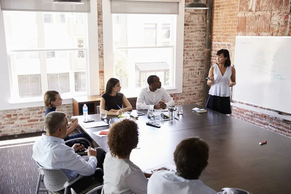 Asian woman talking to collegues — Stock Photo, Image