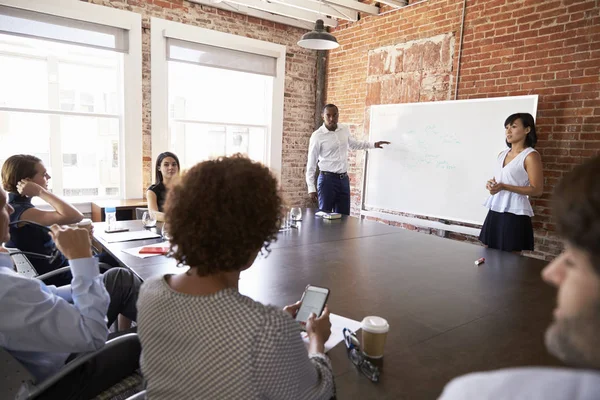 Geschäftsleute am Whiteboard halten Vortrag — Stockfoto