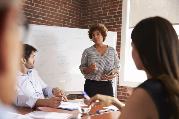 Businesswoman standing in front of table — Stock Photo, Image