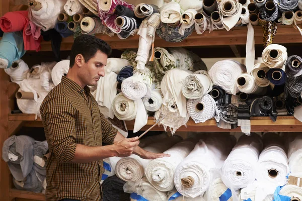 Man using selects fabric — Stock Photo, Image