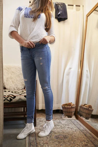 Женщина примеряет джинсы — стоковое фото