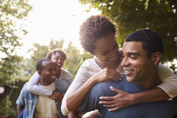 Les jeunes couples s'amusent et piggybackking — Photo