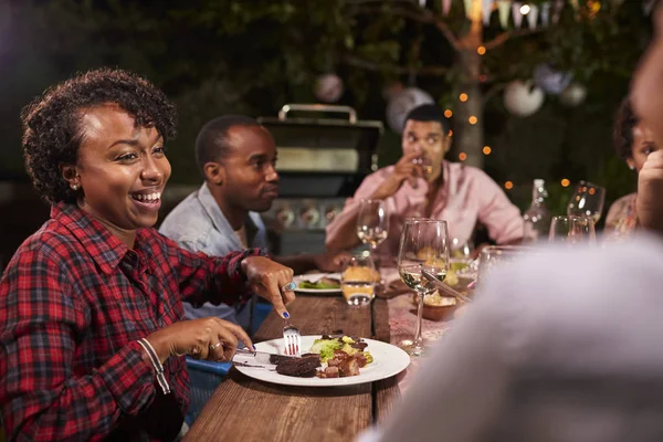 Familie genieten van diner en praten in de tuin — Stockfoto