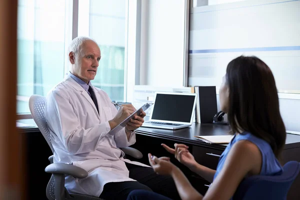 Médico en bata blanca consultando paciente — Foto de Stock