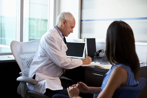 Doctor in de witte jas consulting patiënt — Stockfoto