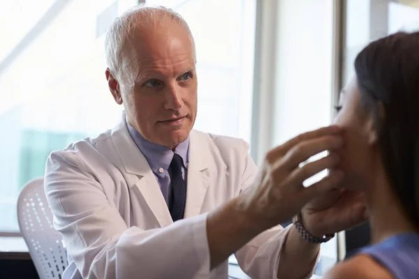 Doctor in white coat examining patient — Stock Photo, Image