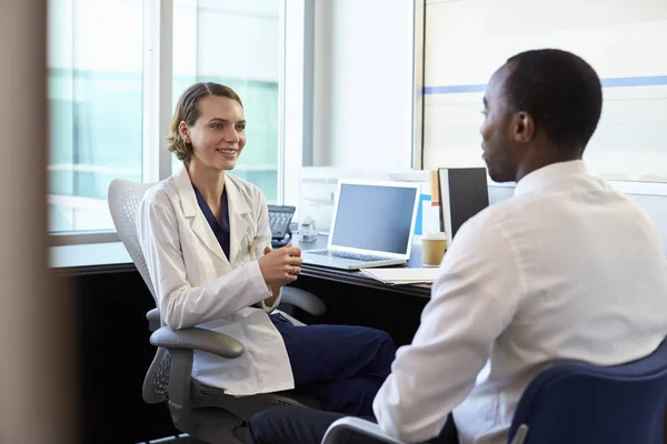 Médico femenino consultando paciente masculino — Foto de Stock