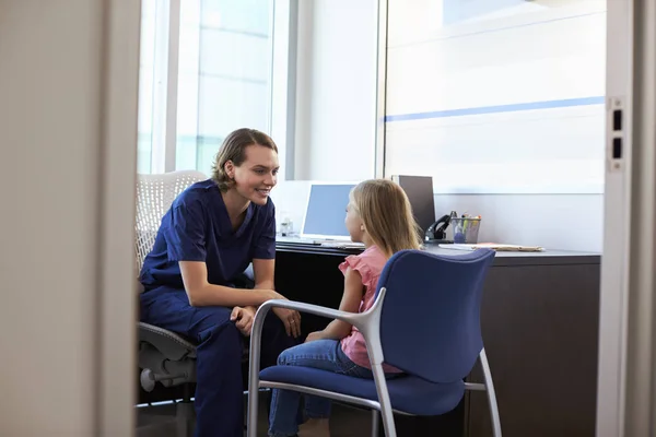 Krankenschwester sitzt und spricht mit Kind — Stockfoto