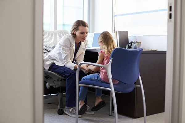 Verpleegkundige in de witte jas in gesprek met kind — Stockfoto