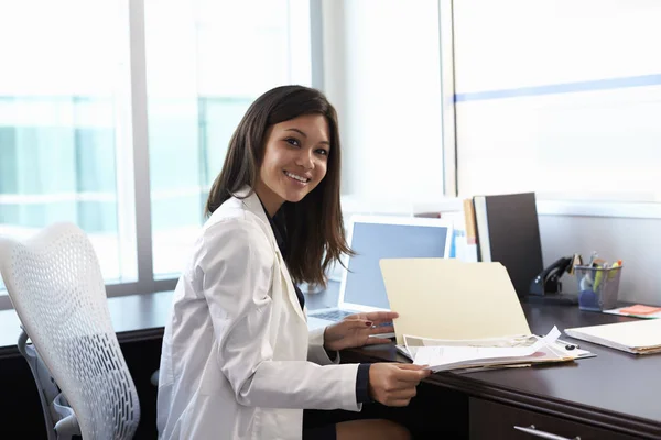 Kvinnliga läkare i coat tittar på kameran — Stockfoto