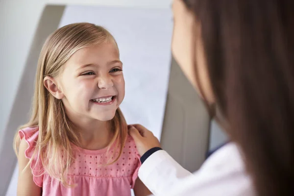 Kinderarzt im weißen Kittel berät Kind — Stockfoto