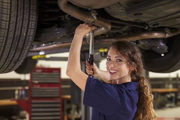 Kvinnliga bilmekaniker som arbetar under bil — Stockfoto