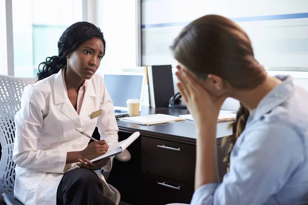 Doctor consulting sad woman Stock Picture