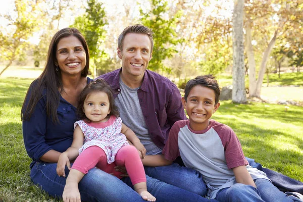 Famille assis sur l'herbe dans le parc — Photo