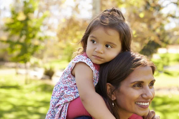 Mère de race mixte portant une jeune fille sur ses épaules — Photo