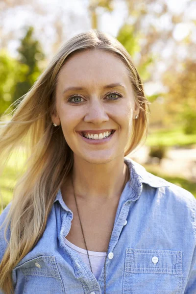 Femme souriant à la caméra dans le parc — Photo