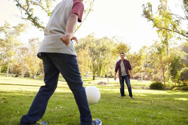 Jongen schoppen bal met vader — Stockfoto