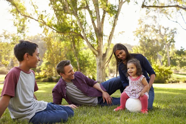 Jong gemengd ras familie ontspannen met voetbal in een park — Stockfoto