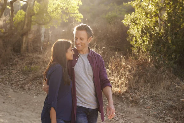 Pareja caminando en parque abrazando — Foto de Stock