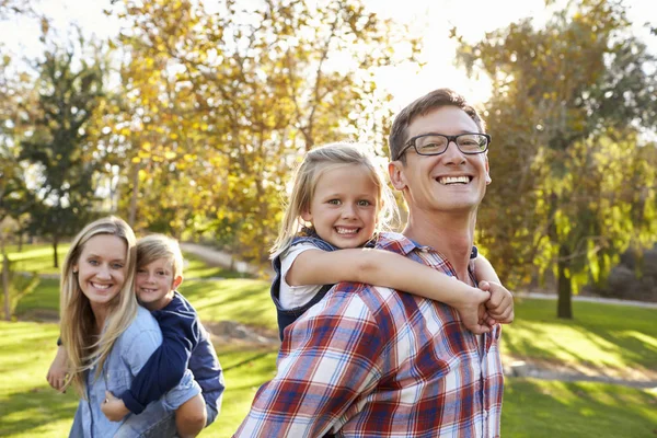 Föräldrar piggyback barn — Stockfoto