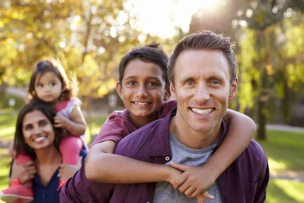 Föräldrar bär barnen piggyback — Stockfoto