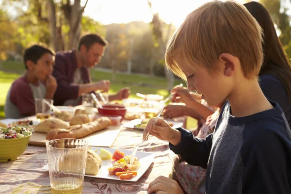 Niño comiendo en una mesa de picnic en un parque — Foto de Stock