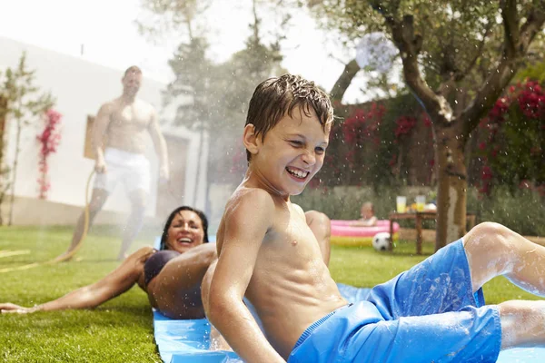 Αγόρι και γονείς διασκεδάζουν στην τσουλήθρα νερού — Φωτογραφία Αρχείου
