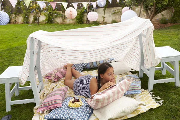 Ragazza che legge libro nel giardino fatto in casa — Foto Stock