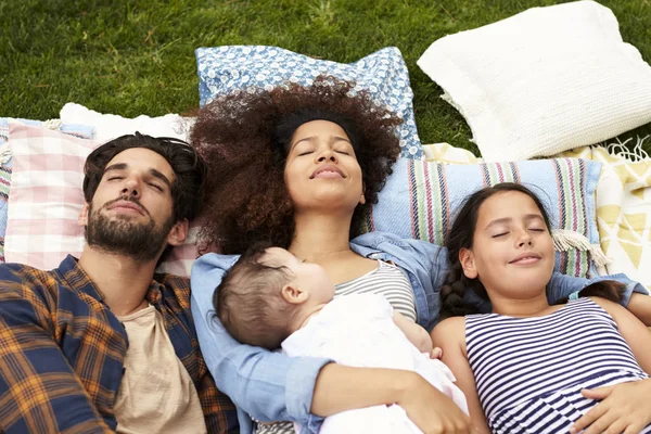 Familjen dagdrömmer på matta i trädgården — Stockfoto