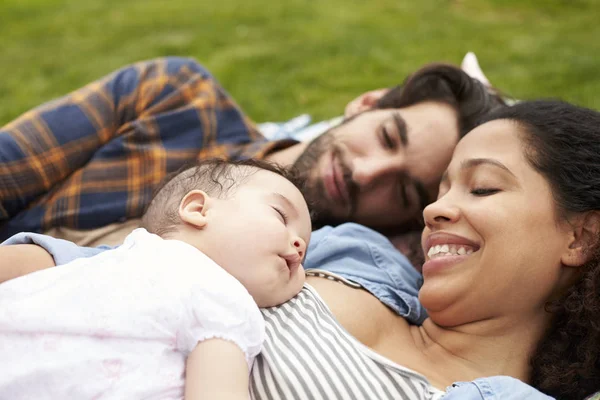 Família sonhando acordado no tapete no jardim — Fotografia de Stock