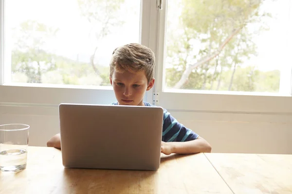 男孩在表上使用笔记本电脑 — 图库照片