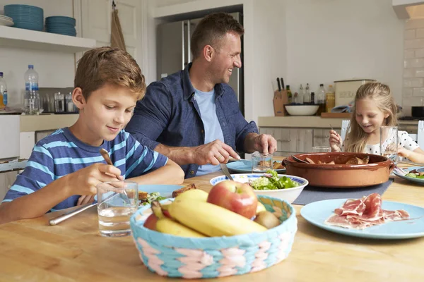 Vader en kinderen aan tafel zit — Stockfoto